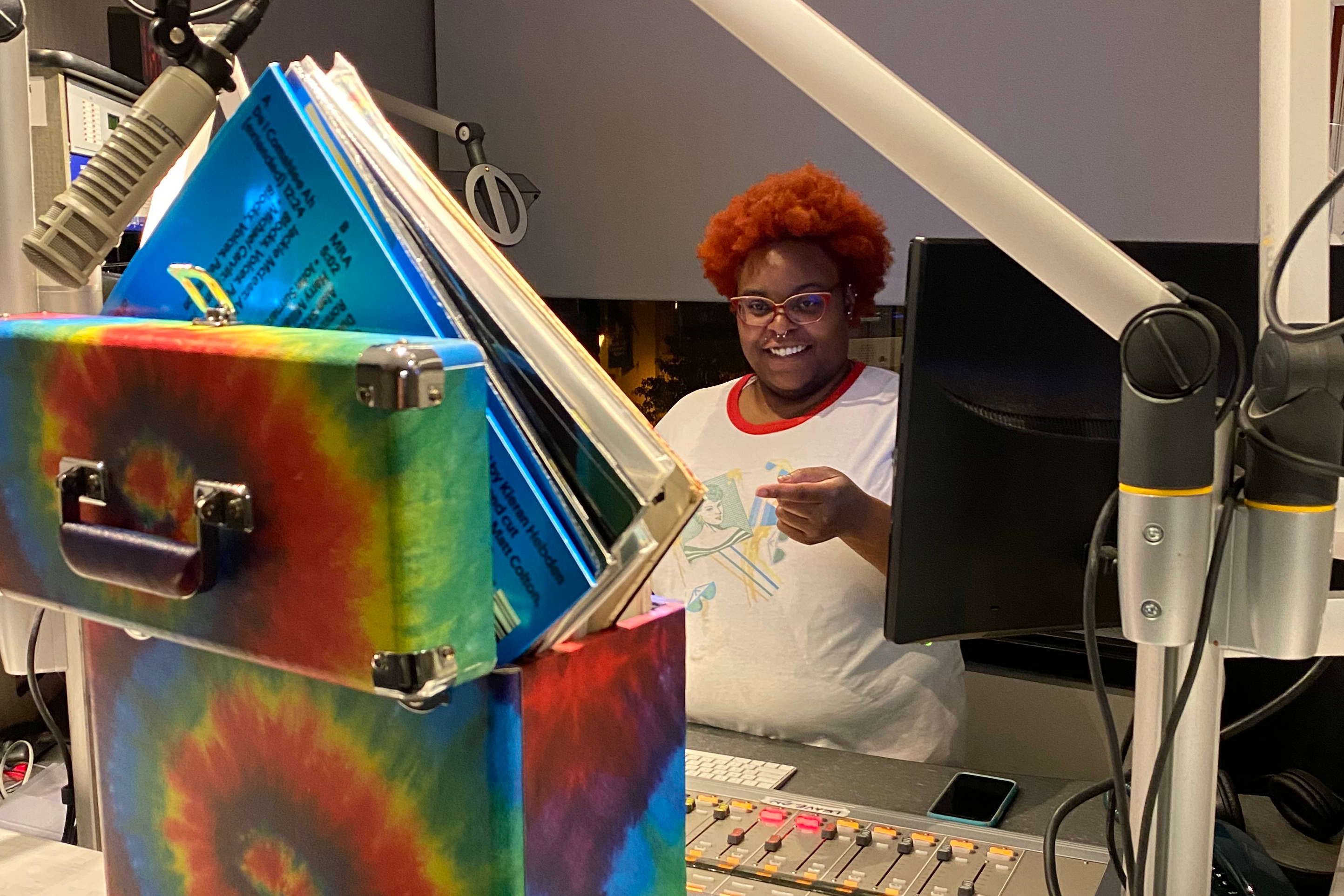 DJ Crim Dolla Cray standing at the control board at KDHX.